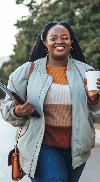 woman with coffee and tablet walking
