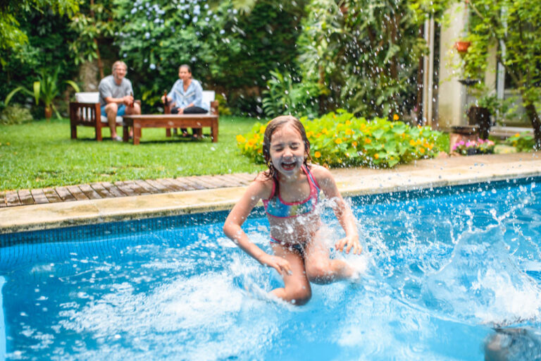 Young Girl Jumping Into Backyard Pool image