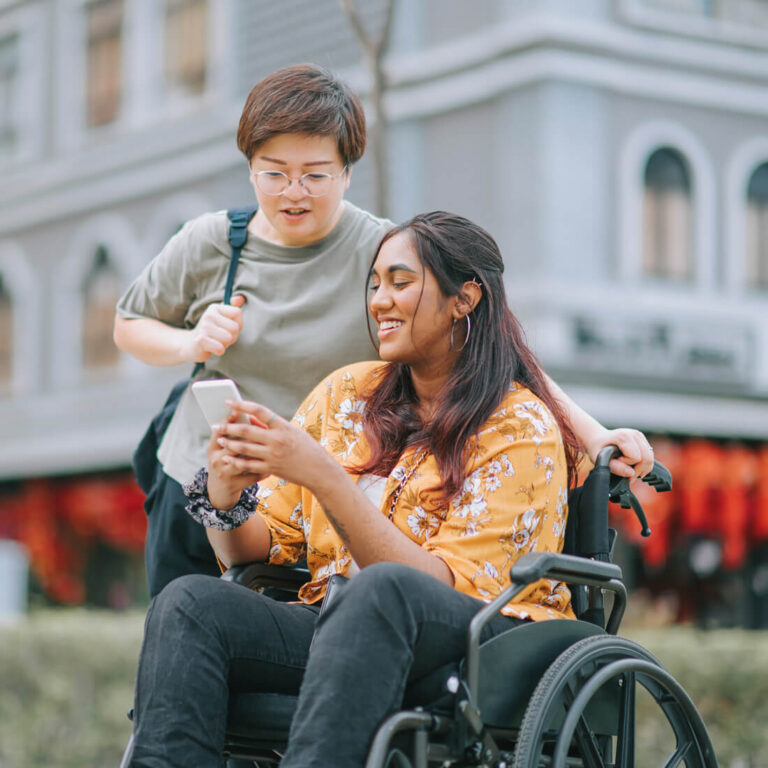 Woman in a wheel chair looking at her phone image
