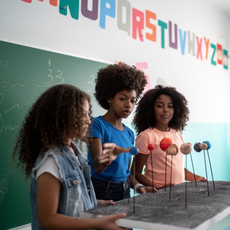 Girls doing a presentation about the Solar System in the classroom