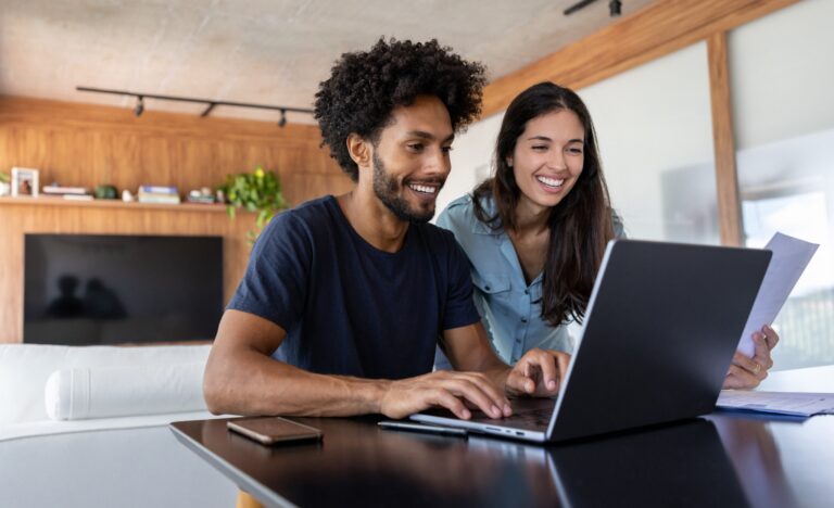 Young couple at home paying bills online on a laptop computer