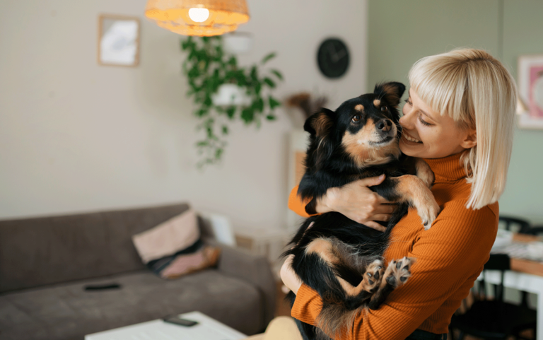 Woman with dog smiling in home