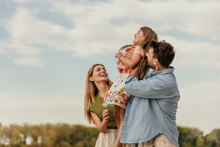 family smiling outside