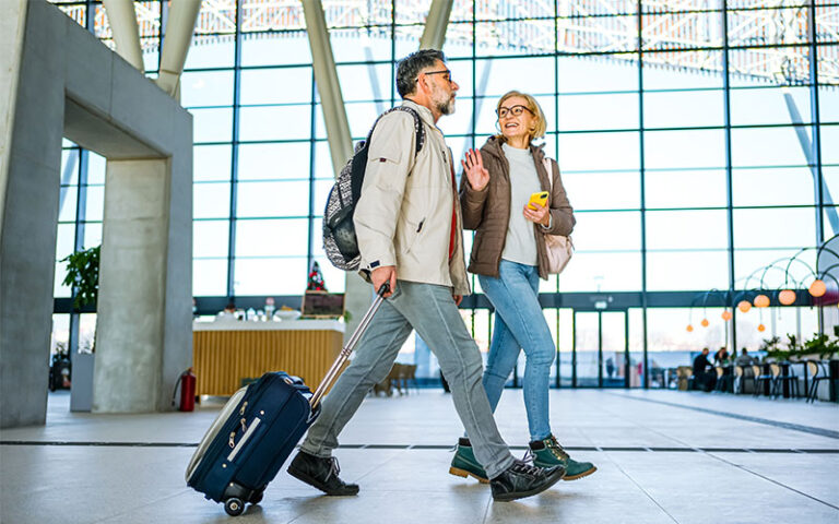 Couple walking through airport terminal for holiday travel.